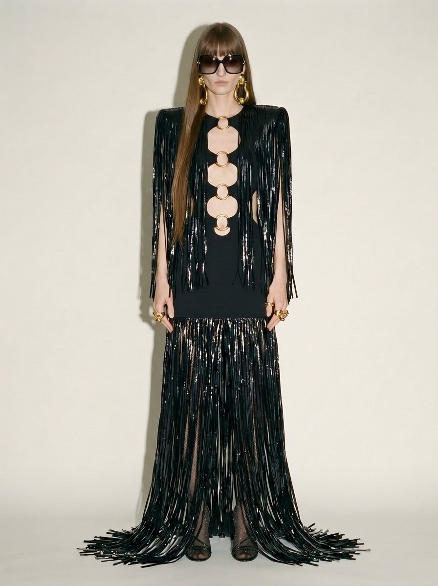 Woman wearing black ring embellished cotton gown with high-shine vinyl fringe.